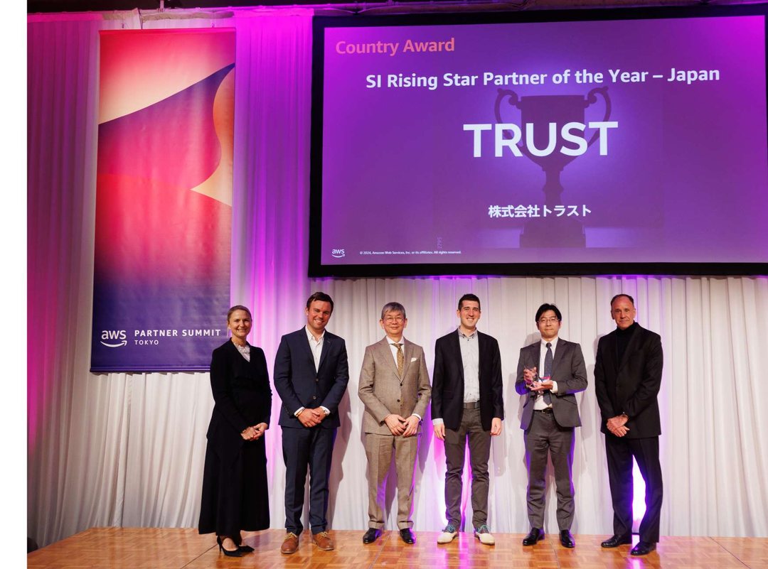 AWS Partner Summit Tokyo の授賞式。スクリーンに SI Rising Star Partner of the Year – Japan 株式会社トラスト と表示されている